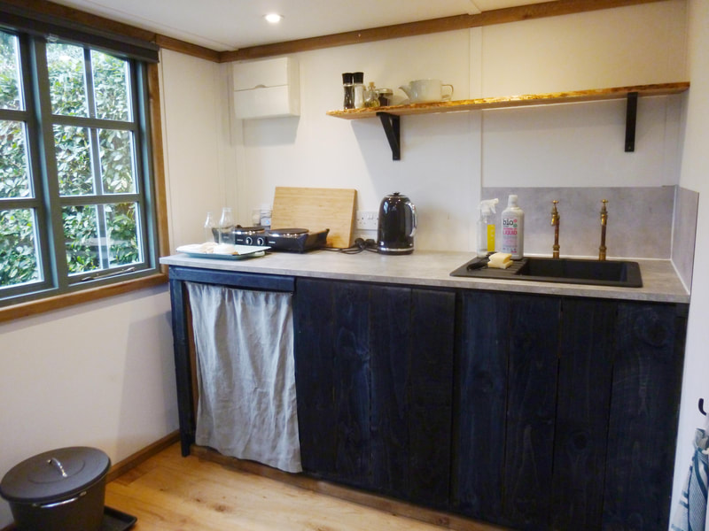 Rustic kitchen in log cabin, Hampshire.